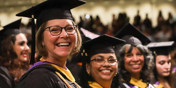 middle-aged woman smiling at commencement ceremony